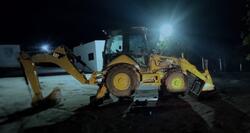 Foto de Uma máquina do tipo retroescavadeira, Caterpillar, 416E, na cor predominante amarela, em bom estado de conservação