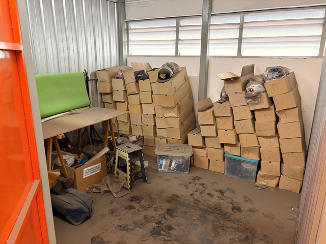 Foto de Box SS3465 - 9m3BENS:88 caixas com diversos bonés em cada, mesa para empacotamento com tecido verde, algumas caixas de papel... Local do bem: Rua Clímaco Barbosa, 700 - Cambucí - São Paulo/SP